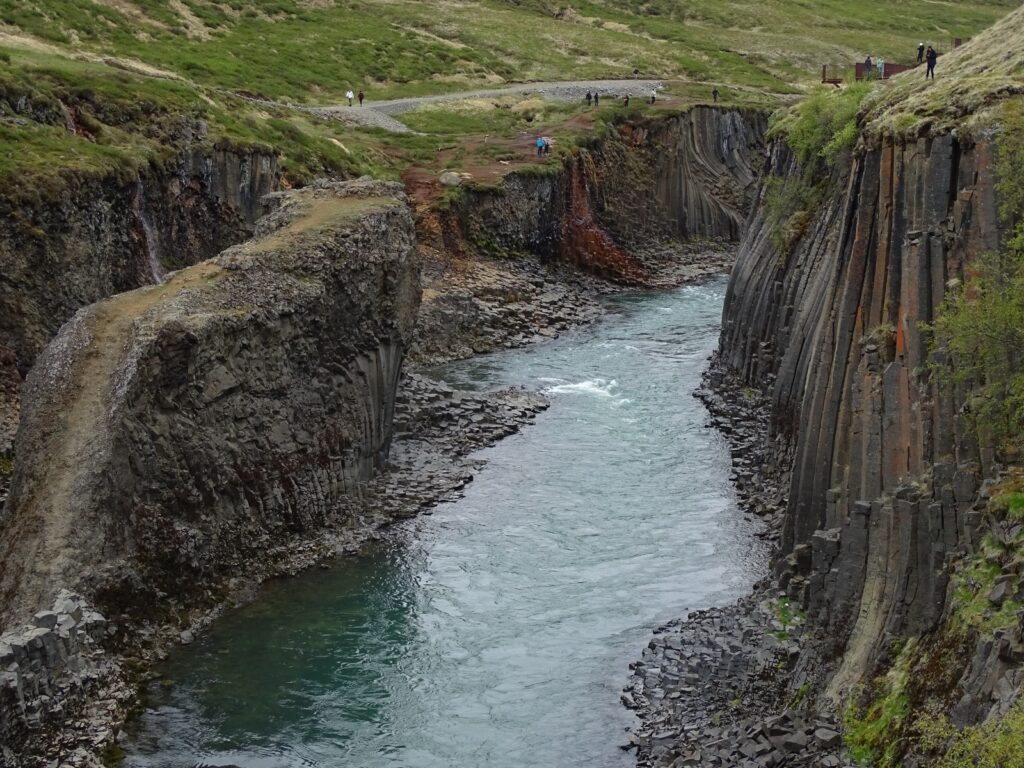 The view up stream Stuðlagil canyon on the south bank looking to the south. The basalt columns, with makes it famous, are seen on both sides of the river. Which is coloured in a greenish blue.