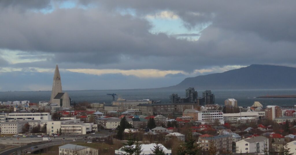 View over Reykjavík seen from the Perlan restaurant. The Hallgrimskirkja is on the left and behind the City is the Esjan Mountain. Between the city and the mountain is the Faxaflói bay. 