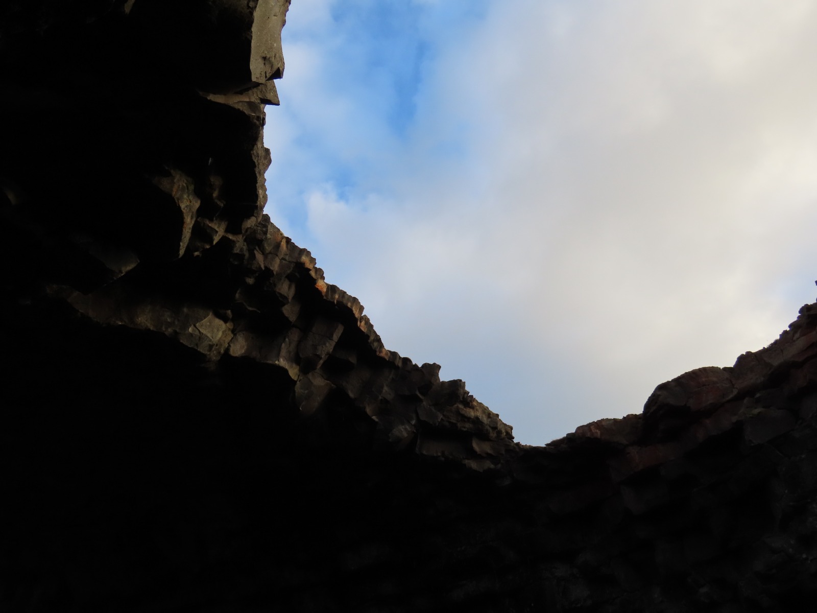 view from inside the cave looking up through the hole in the ceiling