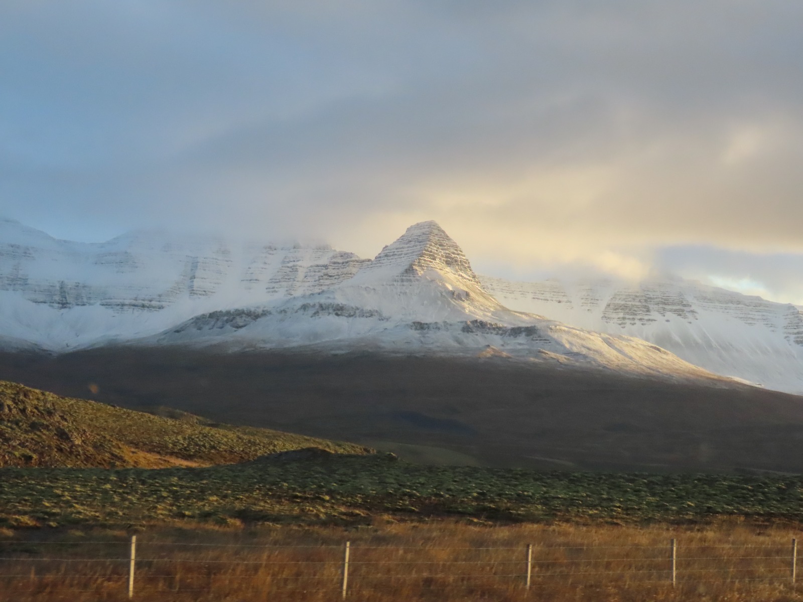 Greenfield in the front and in the background is a glacier